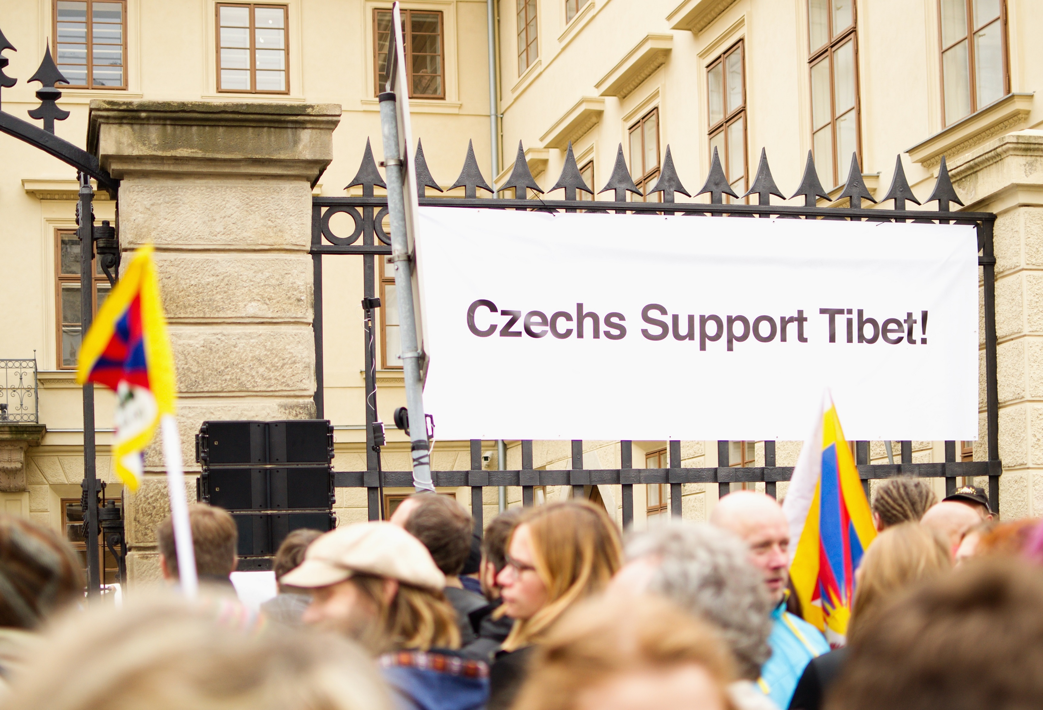 Nápis “Czechs Support Tibet” na plotu v blízkosti pódia