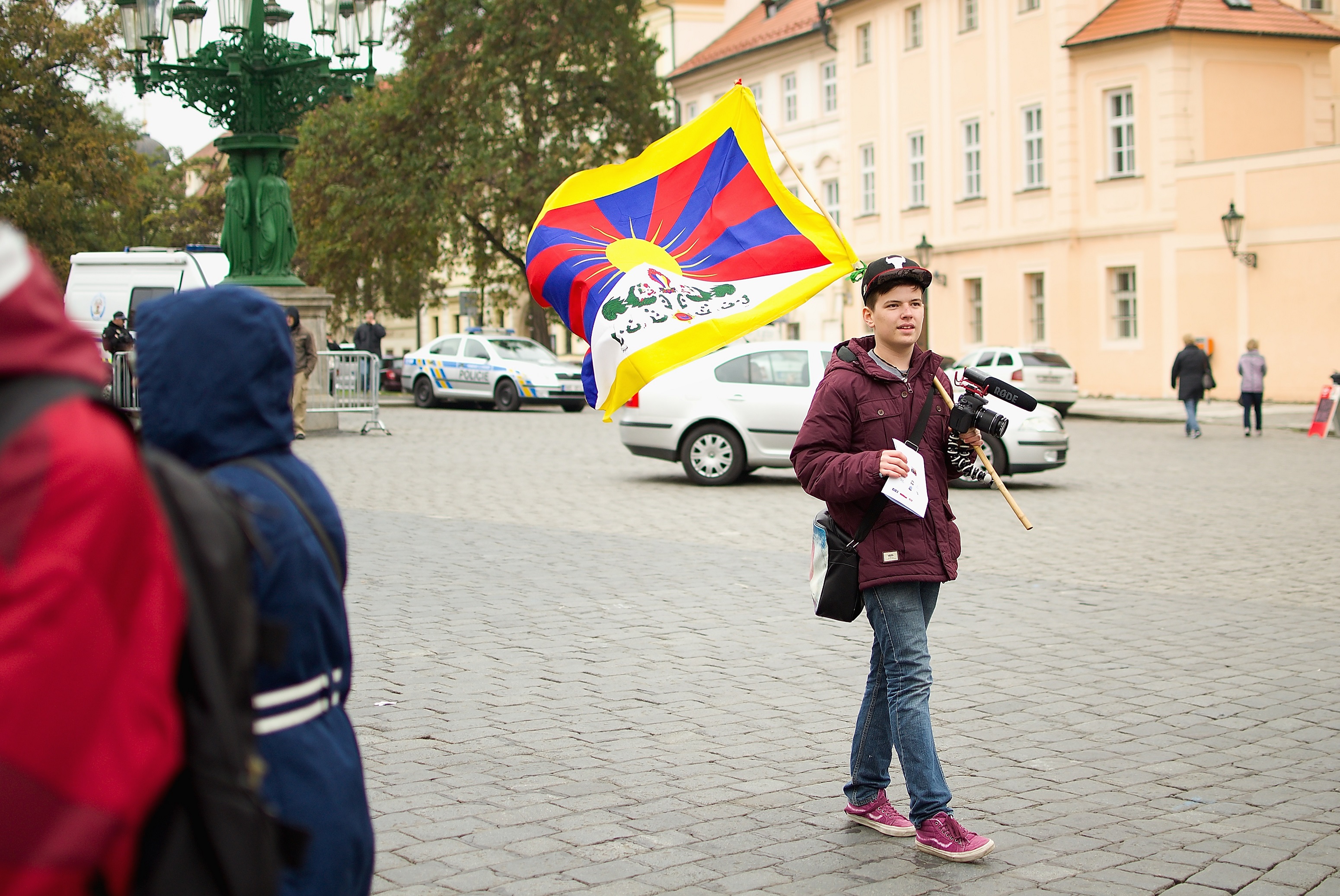Mladík nesoucí tibetskou vlajku na Hradčanském náměstí